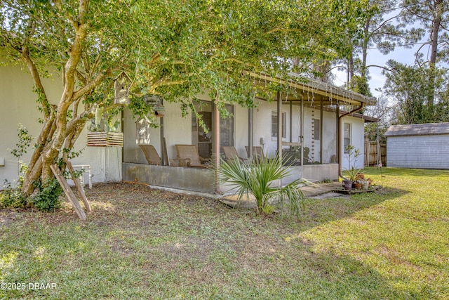 2530 Nordman Ave, New Smyrna Beach, FL 32168 - view of front of house with a sunroom, an outbuilding, stucco siding, and a shed