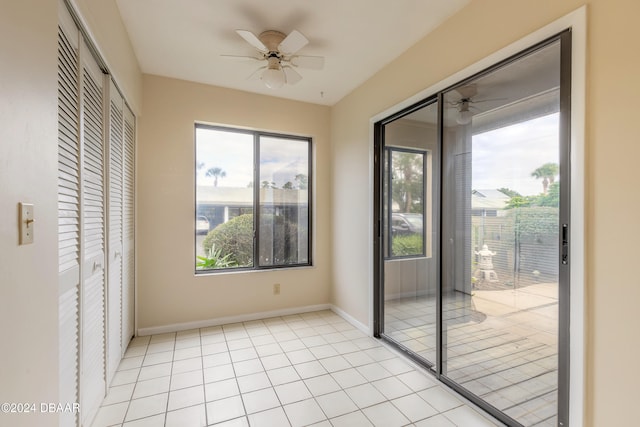 interior space with light tile patterned floors and ceiling fan