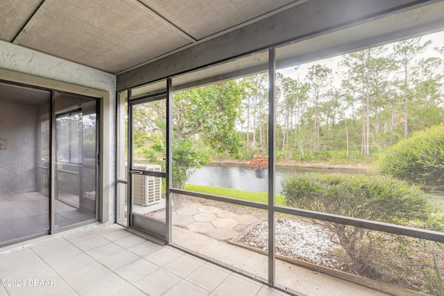 unfurnished sunroom featuring a water view