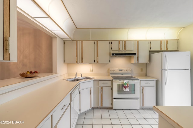 kitchen featuring white appliances, sink, and light tile patterned floors