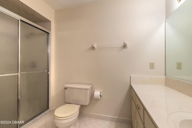 bathroom with tile patterned floors, vanity, toilet, and a shower with shower door