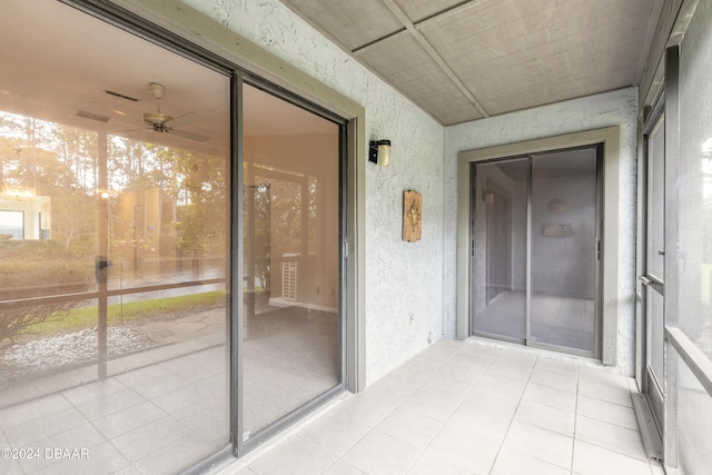 unfurnished sunroom with ceiling fan