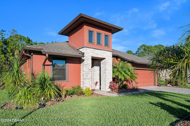 view of front of property with a garage and a front lawn