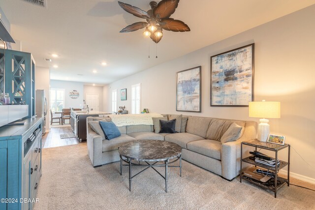 living room featuring light hardwood / wood-style floors and ceiling fan