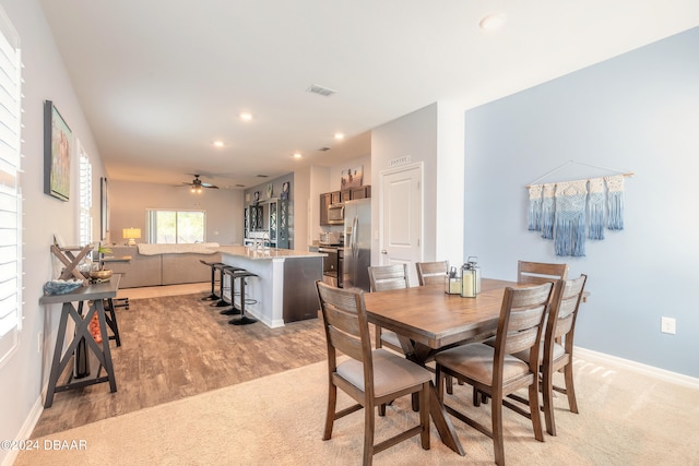 dining space with light wood-type flooring and ceiling fan