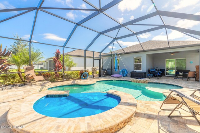 view of swimming pool featuring a patio area, a lanai, and an in ground hot tub