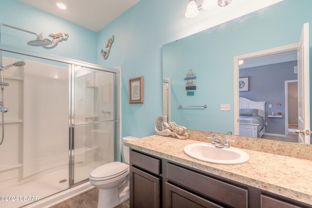 bathroom featuring walk in shower, vanity, toilet, and hardwood / wood-style flooring