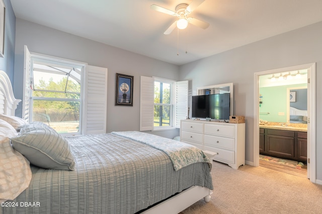 carpeted bedroom featuring ensuite bath, ceiling fan, multiple windows, and sink