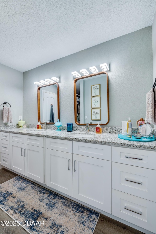 bathroom with a textured ceiling, vanity, and hardwood / wood-style floors