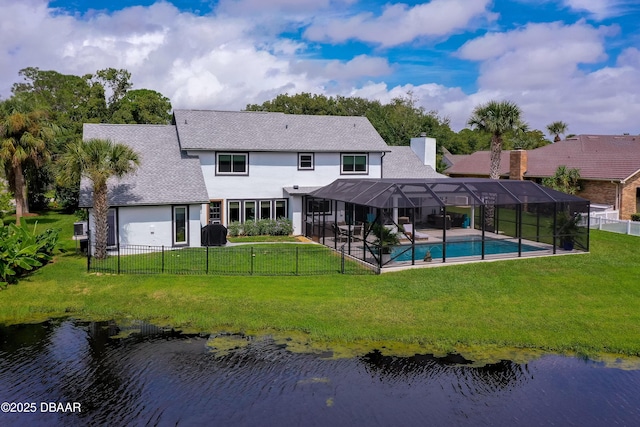 back of house featuring glass enclosure, a fenced in pool, a lawn, and a water view