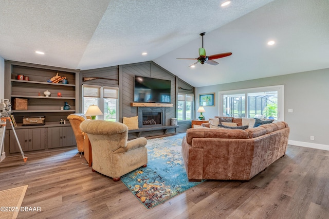 living room with hardwood / wood-style floors, a textured ceiling, and vaulted ceiling