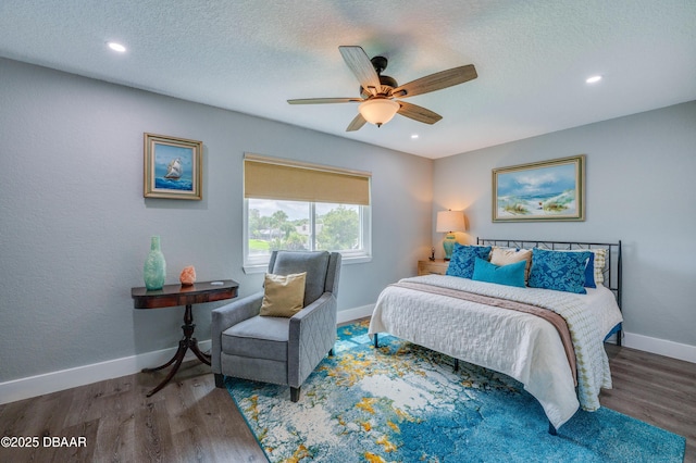 bedroom with a textured ceiling, dark hardwood / wood-style floors, and ceiling fan