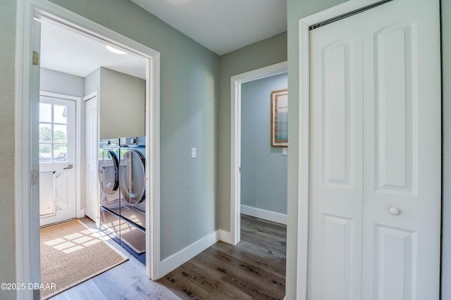 hallway with light wood-type flooring and separate washer and dryer