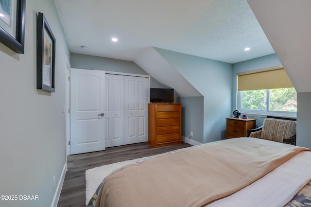 bedroom with a closet, dark hardwood / wood-style floors, and a textured ceiling