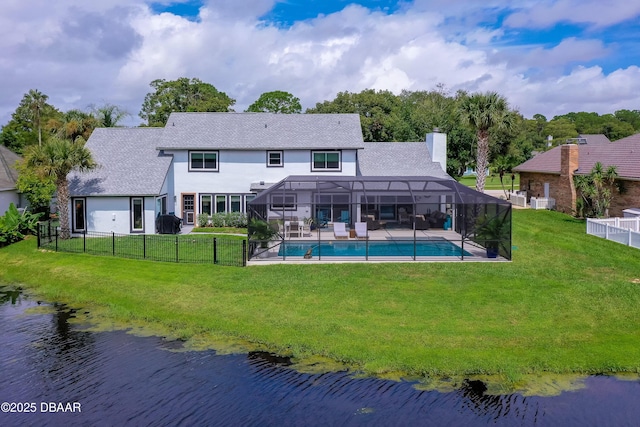 rear view of property featuring glass enclosure, a fenced in pool, a yard, and a water view