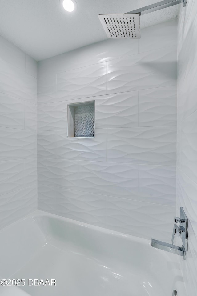 bathroom featuring tiled shower / bath