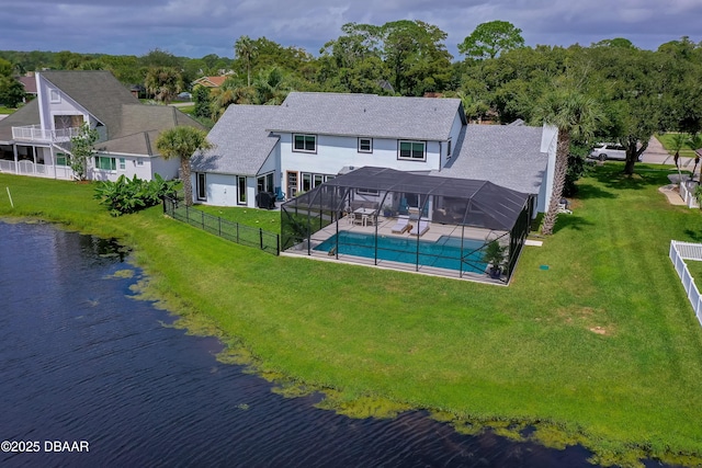 rear view of house featuring a lawn, a fenced in pool, a lanai, and a water view