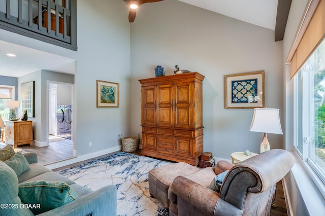 living room featuring wood-type flooring, separate washer and dryer, and a wealth of natural light