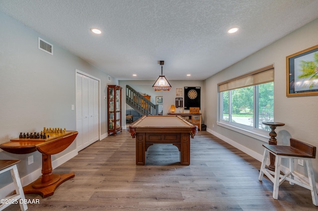 game room with hardwood / wood-style floors and a textured ceiling