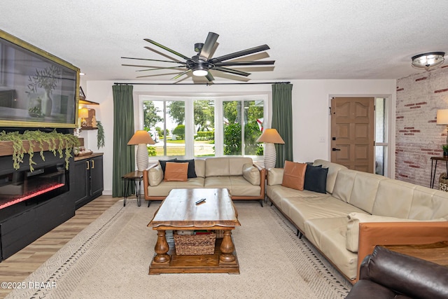 792 N Beach St, Ormond Beach, FL 32174 - living room featuring a textured ceiling, a ceiling fan, wood finished floors, a glass covered fireplace, and brick wall
