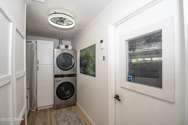 792 N Beach St, Ormond Beach, FL 32174 - laundry room featuring cabinet space, stacked washer and clothes dryer, and light wood-style floors