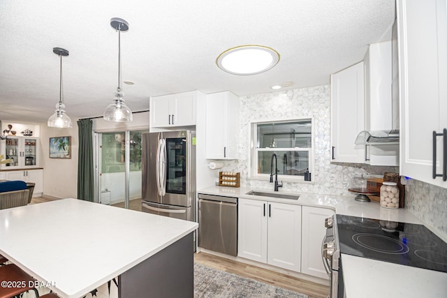 792 N Beach St, Ormond Beach, FL 32174 - kitchen with appliances with stainless steel finishes, tasteful backsplash, light countertops, white cabinets, and a textured ceiling