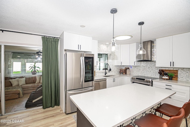 792 N Beach St, Ormond Beach, FL 32174 - kitchen featuring appliances with stainless steel finishes, wall chimney exhaust hood, a kitchen bar, decorative backsplash, and a textured ceiling