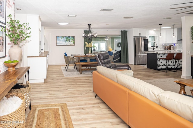 792 N Beach St, Ormond Beach, FL 32174 - living room featuring light wood-style floors and a chandelier
