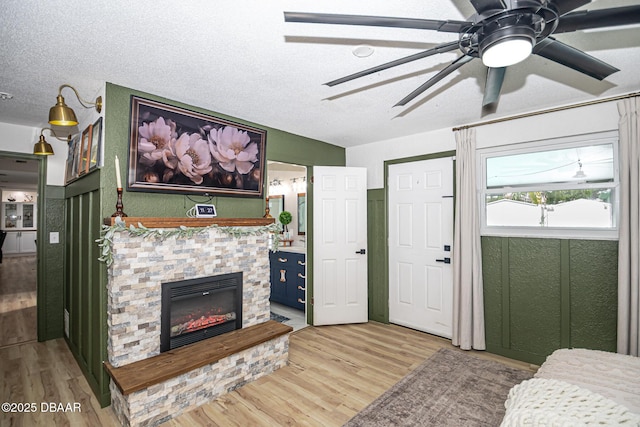 792 N Beach St, Ormond Beach, FL 32174 - living room with light wood-type flooring, a fireplace, a ceiling fan, and a textured ceiling