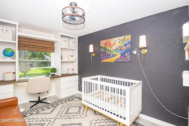 792 N Beach St, Ormond Beach, FL 32174 - bedroom with built in desk, a nursery area, wood finished floors, and a textured wall