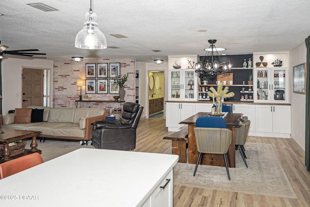 792 N Beach St, Ormond Beach, FL 32174 - living room featuring light wood-type flooring, a textured ceiling, a chandelier, and ceiling fan
