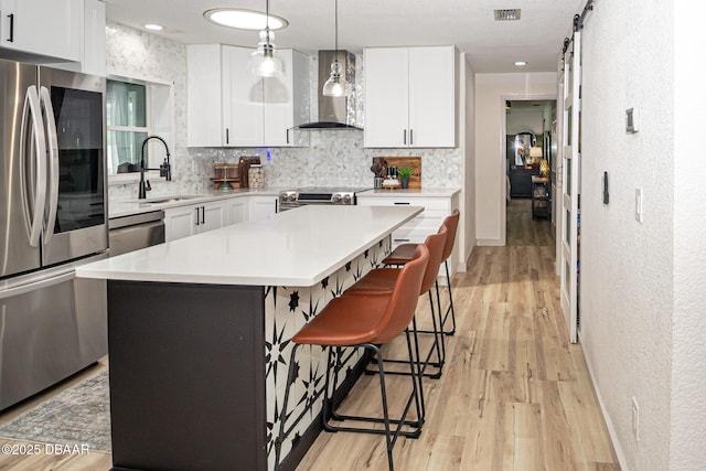792 N Beach St, Ormond Beach, FL 32174 - kitchen with appliances with stainless steel finishes, wall chimney exhaust hood, decorative backsplash, a kitchen bar, and light countertops