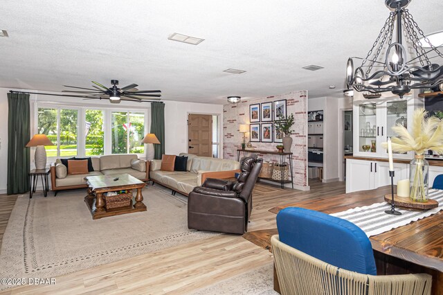 792 N Beach St, Ormond Beach, FL 32174 - living room featuring a chandelier, a textured ceiling, a ceiling fan, and wood finished floors
