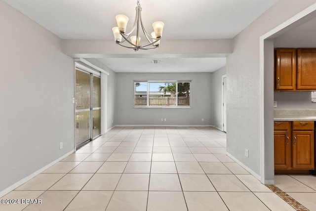 unfurnished dining area with light tile patterned flooring and an inviting chandelier