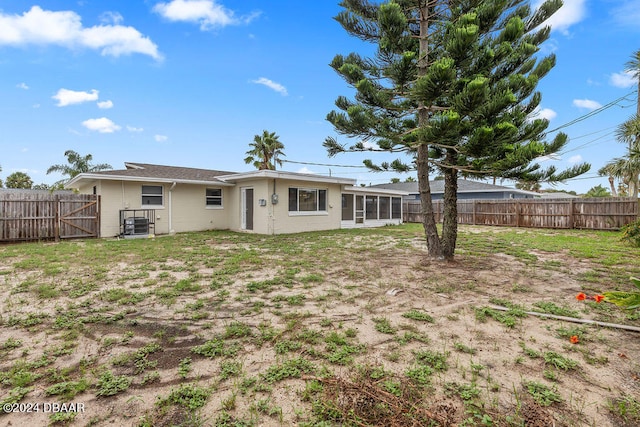 back of property featuring a sunroom and a yard