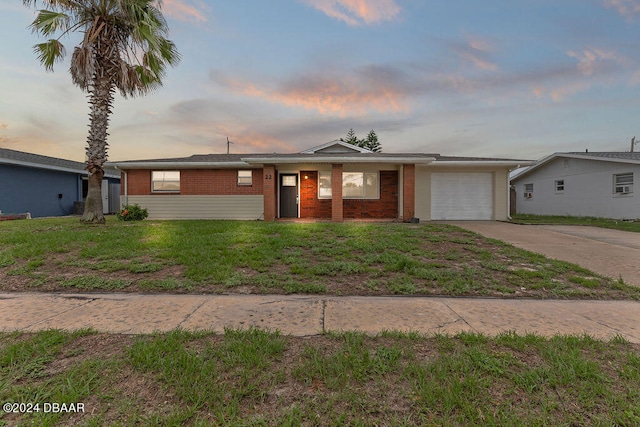 ranch-style house featuring a lawn and a garage