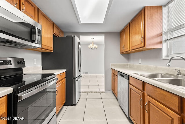 kitchen with sink, hanging light fixtures, stainless steel appliances, a chandelier, and light tile patterned flooring