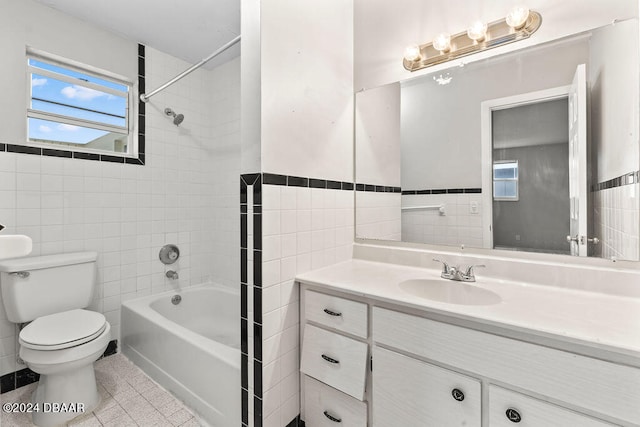 full bathroom with toilet, tile walls, and tiled shower / bath