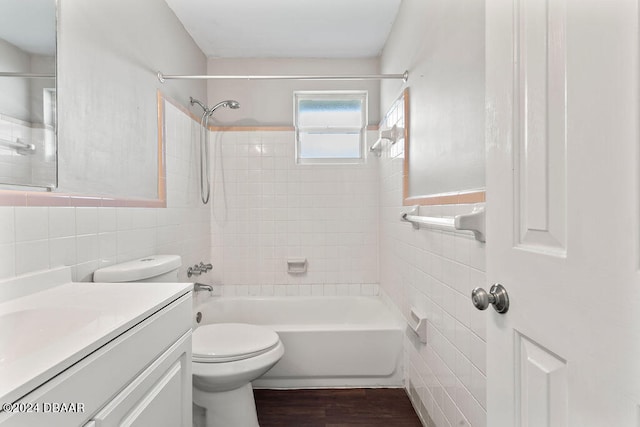 full bathroom featuring vanity, tile walls, hardwood / wood-style floors, toilet, and tiled shower / bath