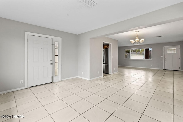 foyer with a chandelier and light tile patterned flooring