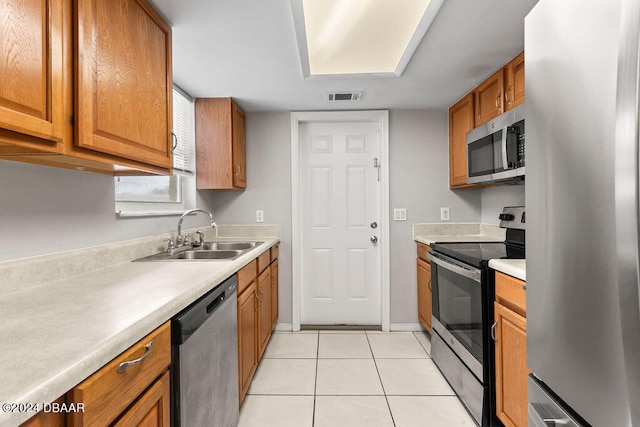 kitchen with sink, light tile patterned floors, and stainless steel appliances