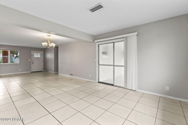 tiled empty room with a chandelier