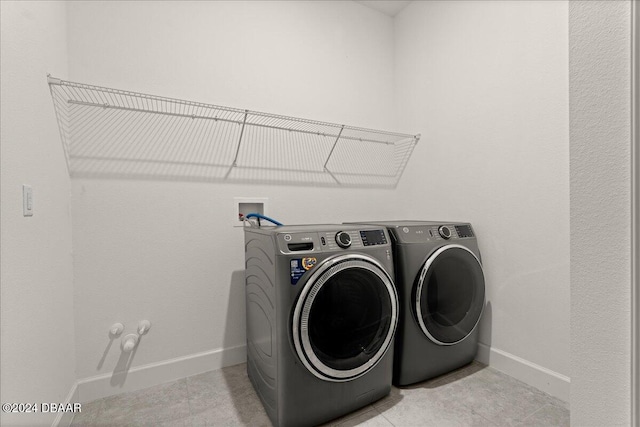 laundry room featuring light tile patterned floors and washer and clothes dryer