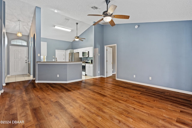 unfurnished living room featuring high vaulted ceiling, wood-type flooring, a textured ceiling, and ceiling fan