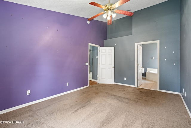 unfurnished bedroom with ensuite bathroom, light carpet, a textured ceiling, and ceiling fan