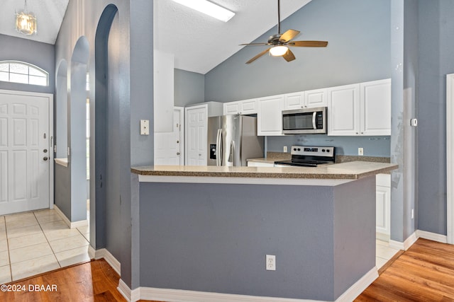 kitchen with light wood-type flooring, kitchen peninsula, and stainless steel appliances