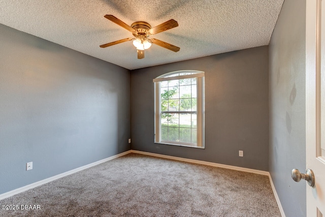 spare room with a textured ceiling, a ceiling fan, baseboards, and carpet floors
