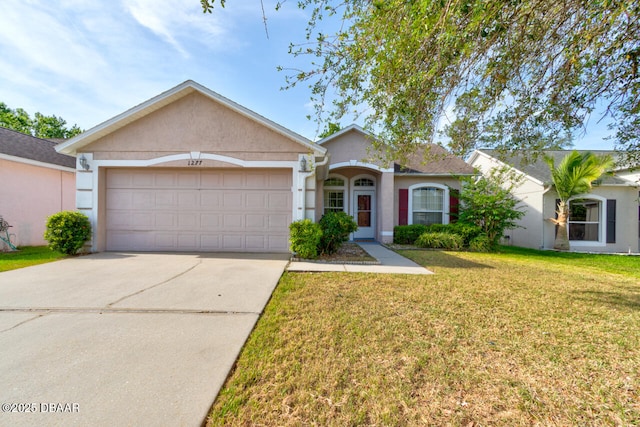 ranch-style house with a garage, stucco siding, driveway, and a front yard