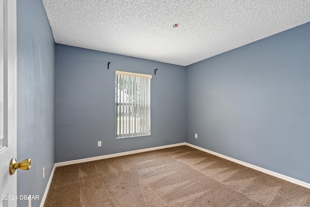 carpeted spare room with a textured ceiling