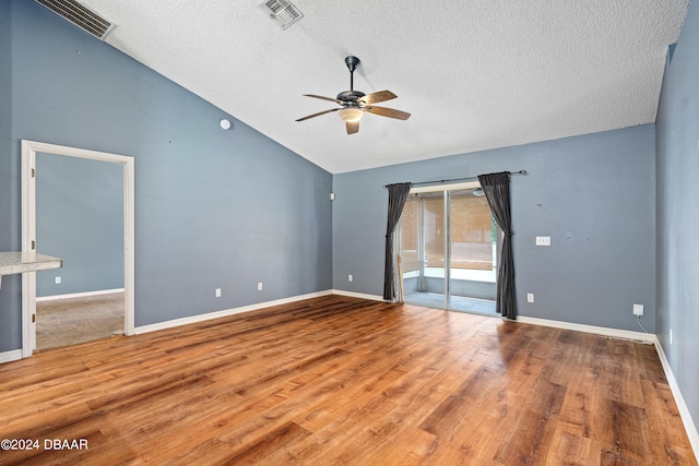 empty room featuring a textured ceiling, vaulted ceiling, ceiling fan, and wood-type flooring